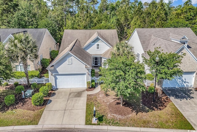 view of front of house featuring fence, concrete driveway, and a garage