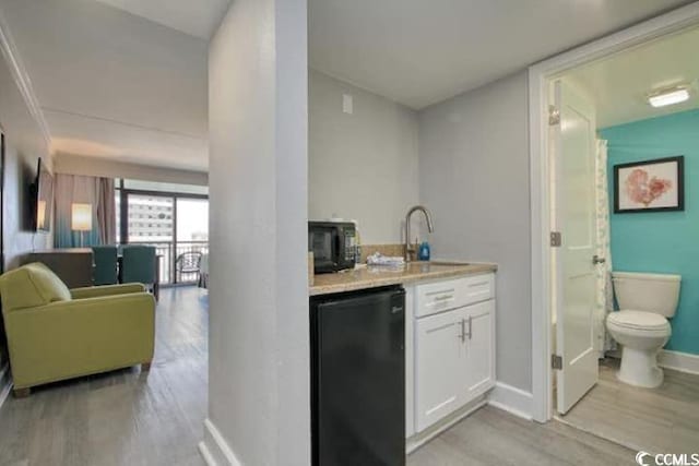 7200 N Ocean Blvd Unit 436, Myrtle Beach, SC 29572 - bar featuring fridge, a sink, indoor wet bar, baseboards, and light wood-type flooring