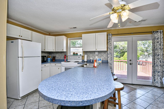 kitchen featuring white appliances, a sink, french doors, a peninsula, and white cabinets