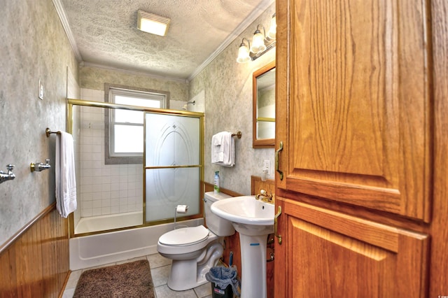 bathroom featuring crown molding, toilet, tile patterned flooring, a textured ceiling, and shower / bath combination with glass door