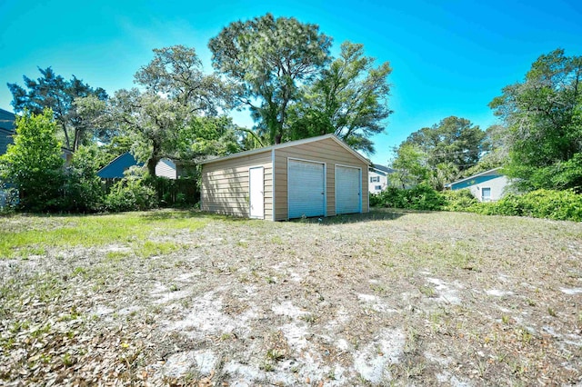 view of yard featuring a detached garage and an outbuilding