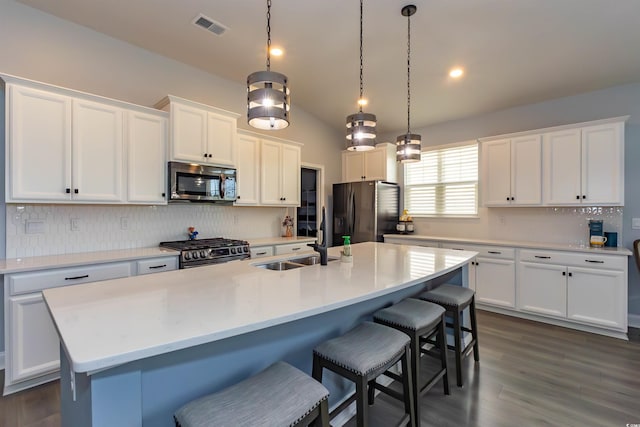 428 Calhoun Falls Dr, Myrtle Beach, SC 29579 - kitchen featuring stainless steel appliances, decorative backsplash, white cabinets, a breakfast bar area, and a sink
