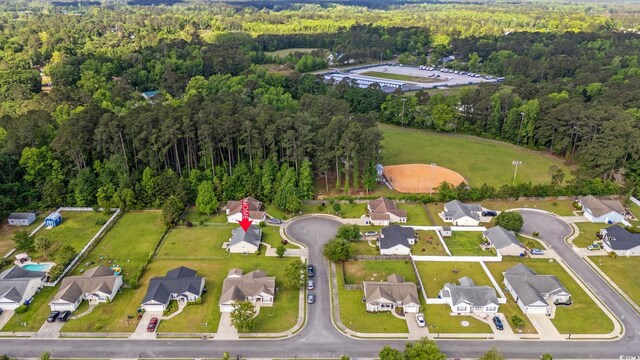 aerial view of property's location featuring a forest and nearby suburban area