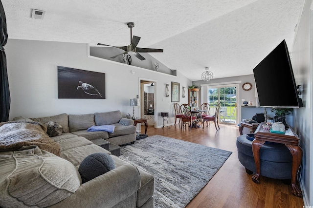 living area featuring a textured ceiling, a ceiling fan, wood finished floors, and vaulted ceiling