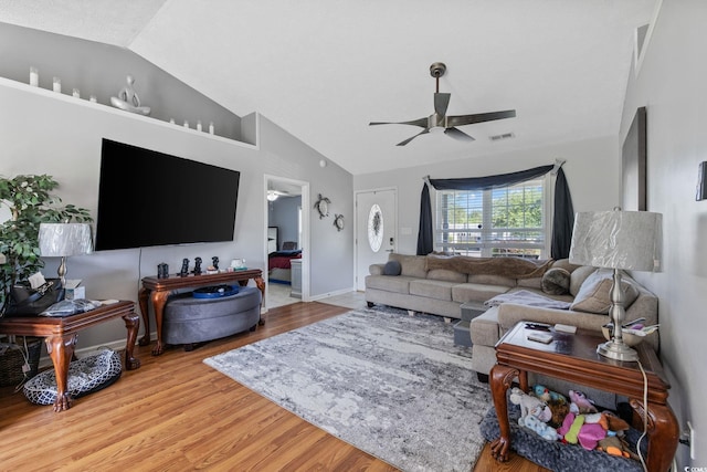 living room featuring a ceiling fan, vaulted ceiling, light wood-type flooring, and baseboards