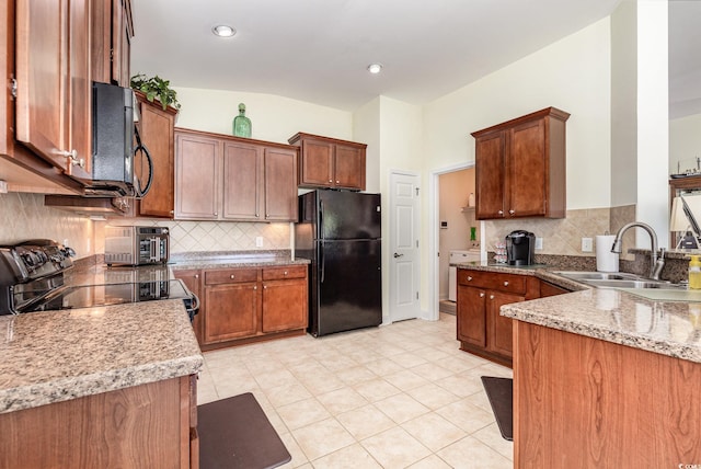 2940 Tigers Eye Rd, Little River, SC 29566 - kitchen with black appliances, a sink, decorative backsplash, and light stone countertops
