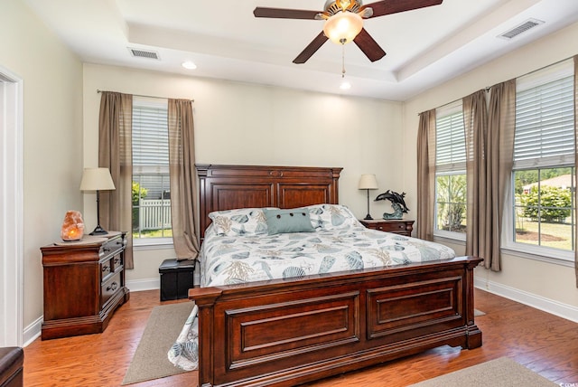 2940 Tigers Eye Rd, Little River, SC 29566 - bedroom featuring a tray ceiling, light wood finished floors, baseboards, and recessed lighting