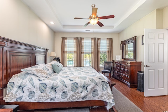 2940 Tigers Eye Rd, Little River, SC 29566 - bedroom featuring a tray ceiling, wood finished floors, a ceiling fan, and recessed lighting
