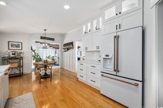 kitchen featuring light countertops, high end fridge, light wood-style flooring, and recessed lighting