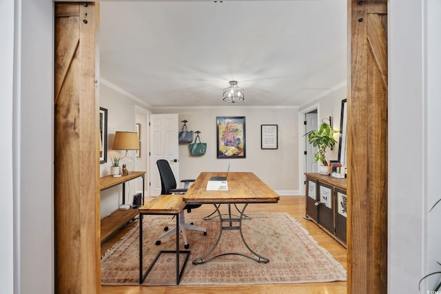 office space featuring baseboards, crown molding, and wood finished floors