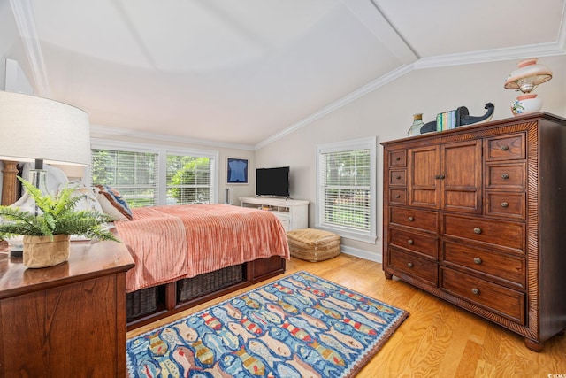 bedroom featuring lofted ceiling, ornamental molding, and light wood-style flooring