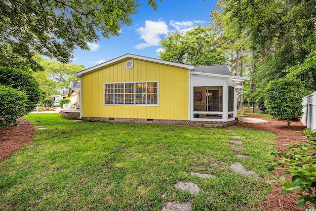 exterior space featuring a yard, a sunroom, fence, and crawl space