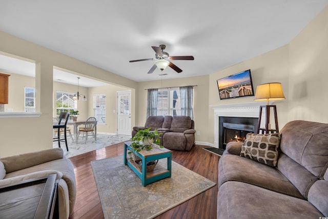 381 Winslow Ave, Myrtle Beach, SC 29588 - living room with baseboards, a ceiling fan, a warm lit fireplace, and dark wood-style floors
