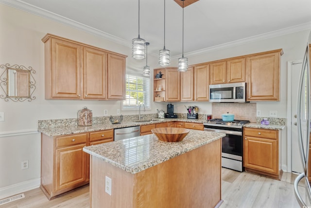 kitchen with a kitchen island, visible vents, appliances with stainless steel finishes, a sink, and light wood-style flooring