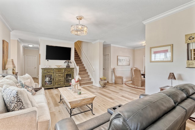 living room featuring an inviting chandelier, ornamental molding, stairs, baseboards, and light wood finished floors
