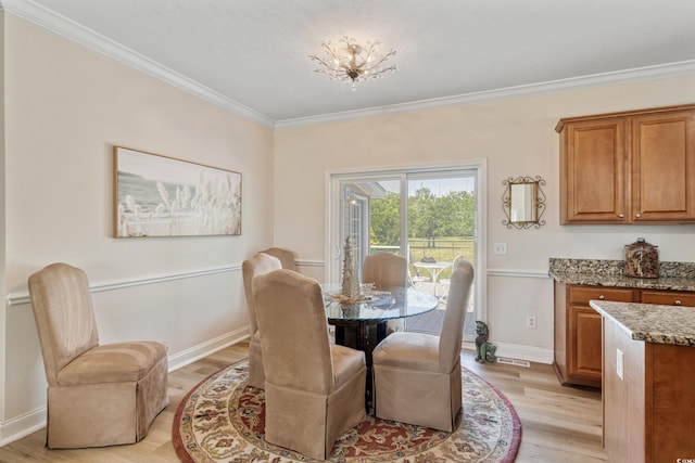 dining space featuring crown molding, baseboards, light wood finished floors, and visible vents