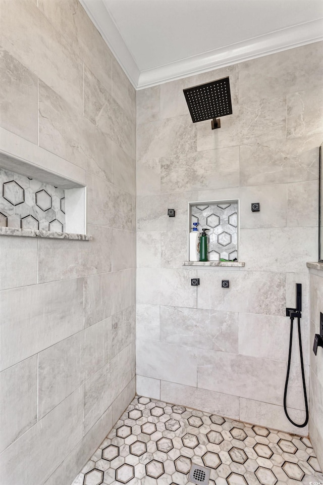 bathroom with crown molding and tiled shower