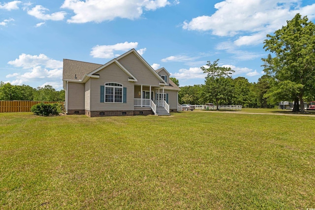 rear view of house with covered porch, crawl space, a yard, and fence