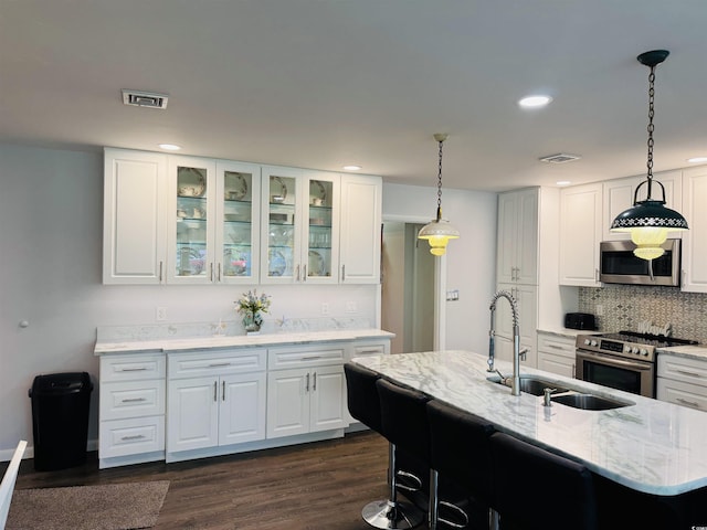 801 Talbot Cir, Myrtle Beach, SC 29577 - kitchen with stainless steel appliances, backsplash, a sink, glass insert cabinets, and light stone counters