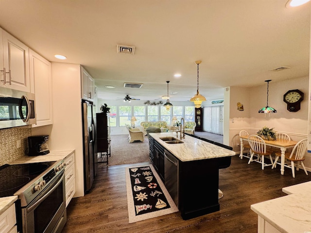 801 Talbot Cir, Myrtle Beach, SC 29577 - kitchen with appliances with stainless steel finishes, a sink, open floor plan, white cabinets, and recessed lighting