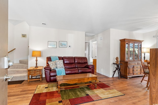 living room featuring light wood finished floors and stairway