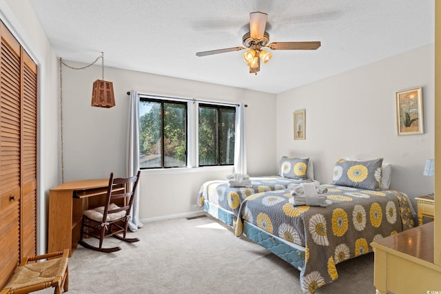 carpeted bedroom with baseboards, ceiling fan, and a closet