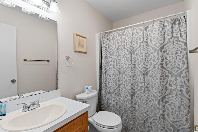 bathroom featuring vanity, curtained shower, and toilet