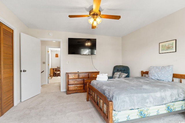 bedroom featuring light colored carpet, a ceiling fan, and baseboards