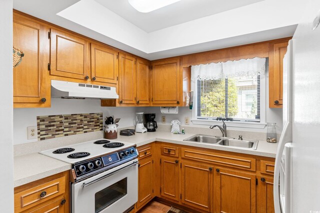 607A 28th Ave S, North Myrtle Beach, SC 29582 - kitchen with white appliances, a sink, under cabinet range hood, light countertops, and brown cabinetry