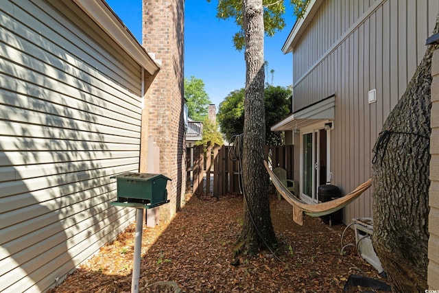 view of home's exterior with board and batten siding and fence