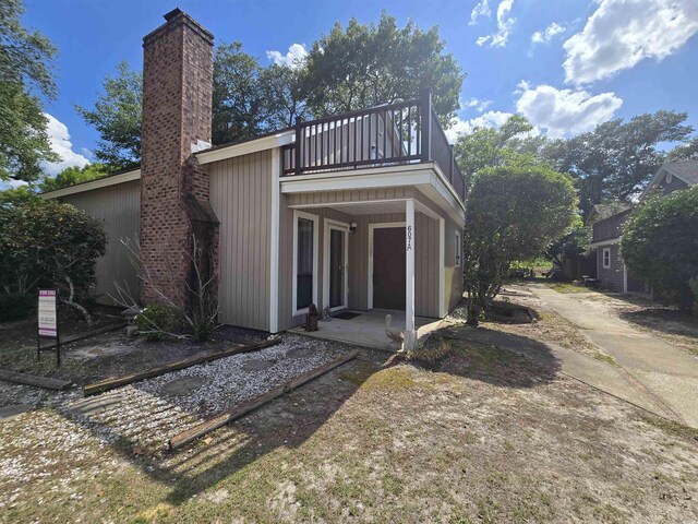 607A 28th Ave S, North Myrtle Beach, SC 29582 - rear view of house with a balcony and a chimney