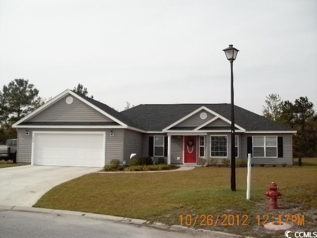 view of front of house with concrete driveway, an attached garage, and a front lawn