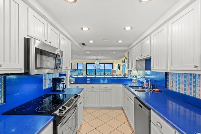 kitchen featuring a sink, appliances with stainless steel finishes, dark countertops, and visible vents