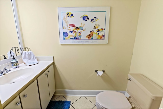 half bath with toilet, tile patterned floors, baseboards, and vanity