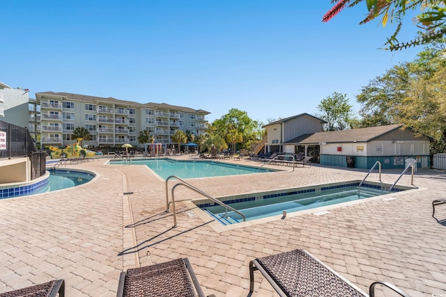 community pool featuring fence and a patio area