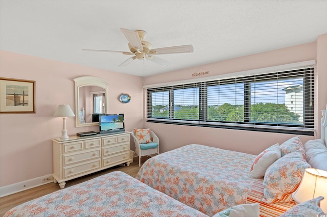 bedroom with baseboards, ceiling fan, and wood finished floors