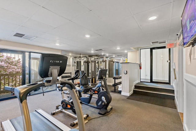 workout area with visible vents, a paneled ceiling, and dark colored carpet