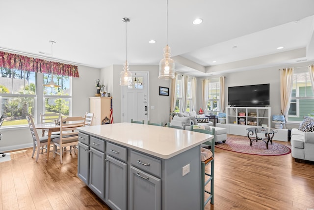 1048 Longwood Bluffs Cir, Murrells Inlet, SC 29576 - kitchen featuring gray cabinets, open floor plan, wood finished floors, a kitchen island, and a breakfast bar