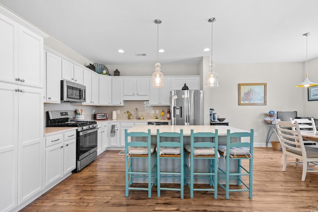1048 Longwood Bluffs Cir, Murrells Inlet, SC 29576 - kitchen featuring appliances with stainless steel finishes, a sink, a kitchen island, white cabinets, and recessed lighting
