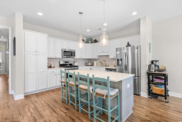 1048 Longwood Bluffs Cir, Murrells Inlet, SC 29576 - kitchen featuring stainless steel appliances, a sink, light wood-type flooring, a center island, and light countertops