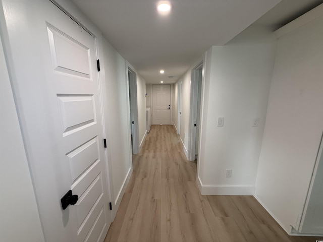 hallway featuring recessed lighting, baseboards, and light wood-style flooring
