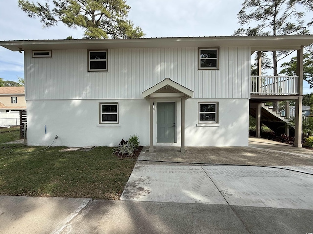 view of front facade featuring stairs, metal roof, a patio area, and a front yard