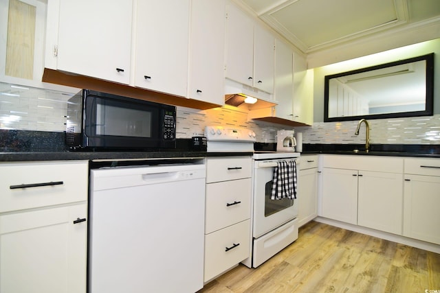 kitchen featuring dark countertops, white cabinetry, white appliances, under cabinet range hood, and tasteful backsplash