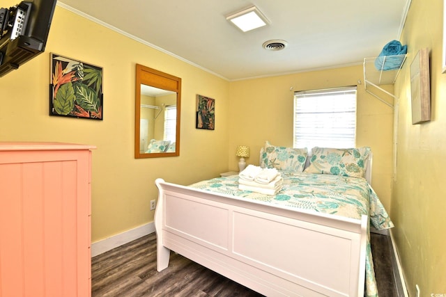 bedroom with ornamental molding, baseboards, visible vents, and dark wood finished floors