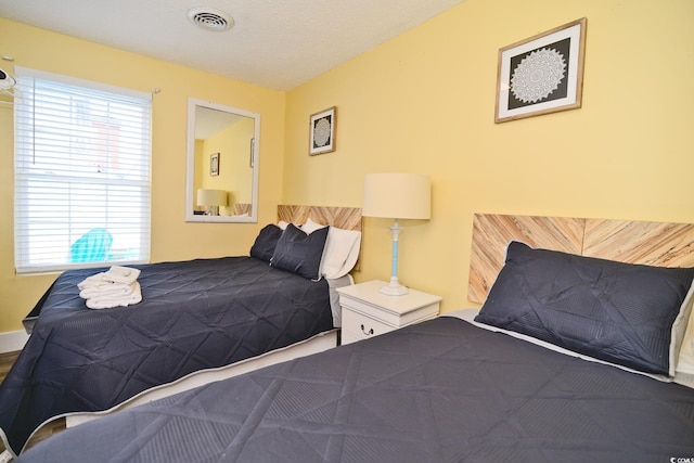 bedroom with visible vents and multiple windows