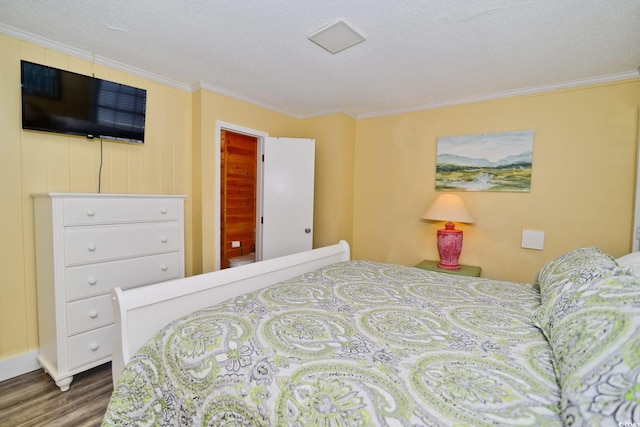 bedroom with crown molding, a textured ceiling, and wood finished floors