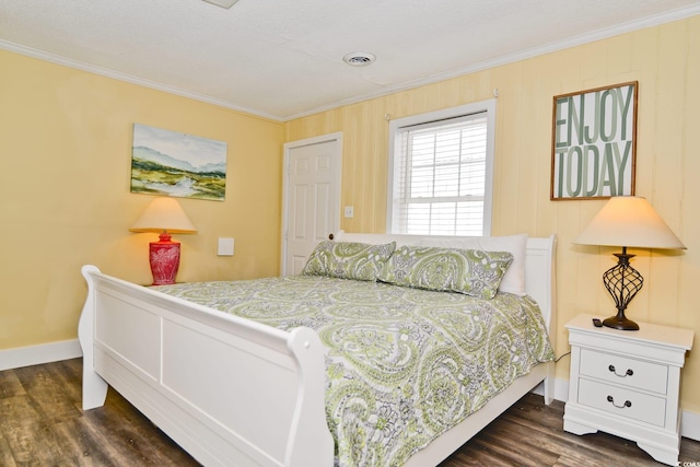 bedroom with visible vents, baseboards, ornamental molding, and dark wood-style floors