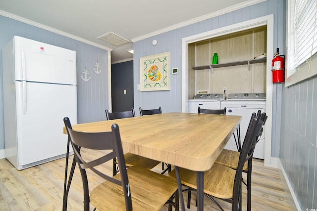 dining room with washer and clothes dryer, light wood finished floors, ornamental molding, and baseboards