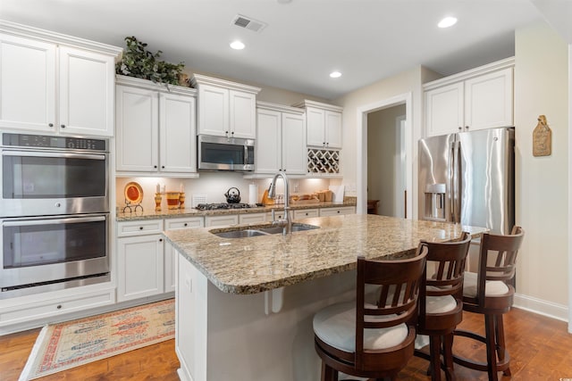 2089 Suncrest Dr, Myrtle Beach, SC 29577 - kitchen featuring appliances with stainless steel finishes, a sink, a kitchen island with sink, wood finished floors, and visible vents