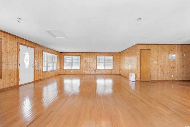 209 25th Ave N, North Myrtle Beach, SC 29582 - unfurnished living room featuring light wood-style flooring, wooden walls, baseboards, and crown molding